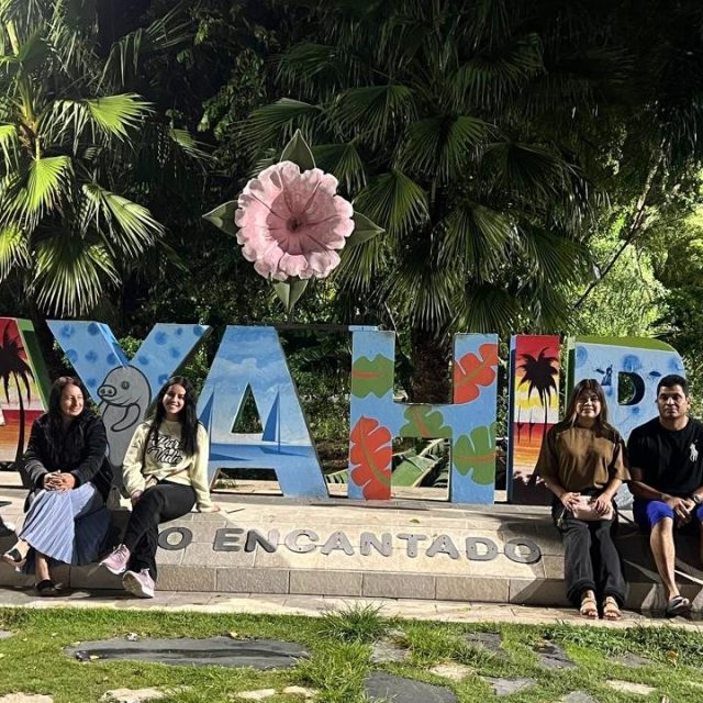 Viajeros frente a las letras turísticas de un destino dominicano